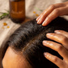 Scalp massage ritual with Atorisé oil - fingers working oil into the scalp