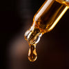 Atorisé golden hair oil drop from glass dropper - close-up macro shot