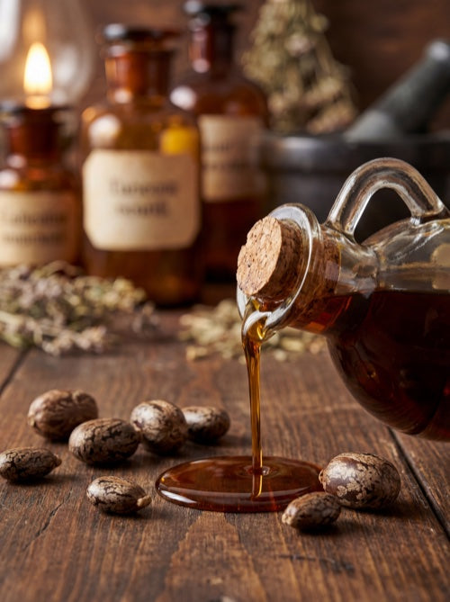 Jamaican black castor oil being poured with castor beans