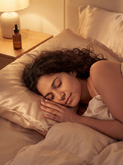 Woman sleeping peacefully with Atorisé on nightstand